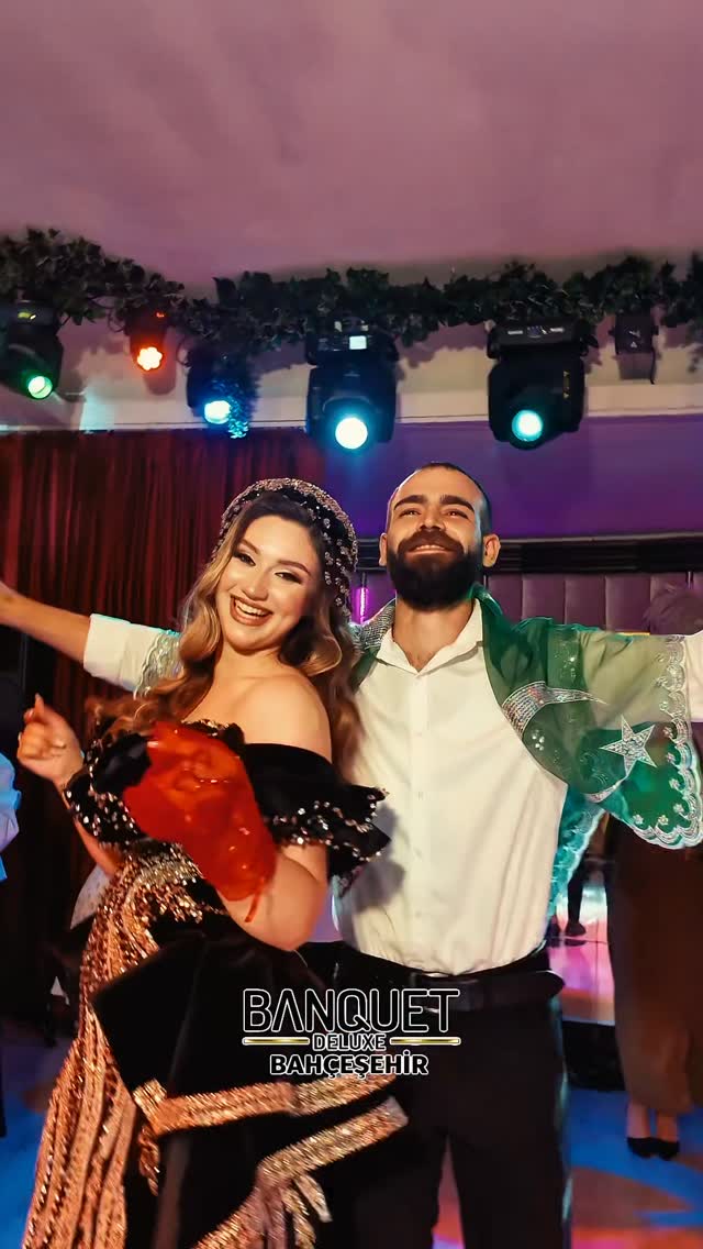 Kına gecesinde dans ederken gülümseyen çift