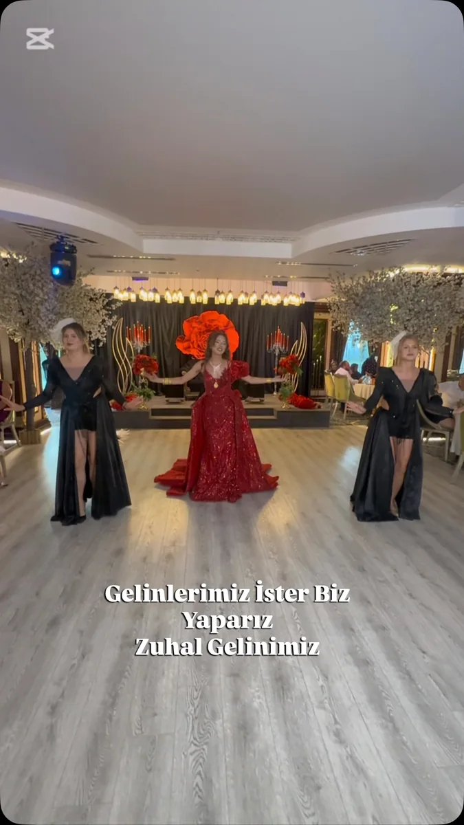 Çiçekli sahne önünde kırmızı kına elbisesiyle dans gösterisi