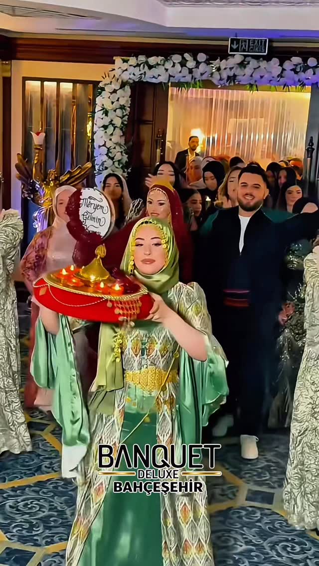 Geleneksel kıyafetli dansçının kırmızı kına tepsisiyle yürüyüşü