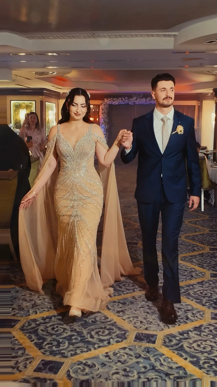 Banquet Deluxe salonunda el ele yürüyen nişan çifti